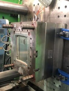 Automotive injection mold mounted on an injection molding machine