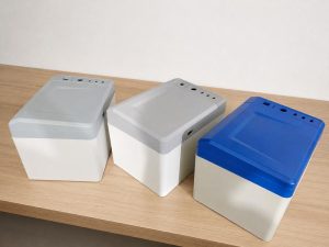 Custom plastic enclosures and machined plastic parts in gray, white, and blue