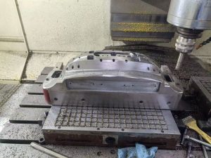Technician inspecting an injection mold in a factory workshop before production