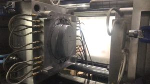 Technician inspecting an injection mold during a trial process before mass production